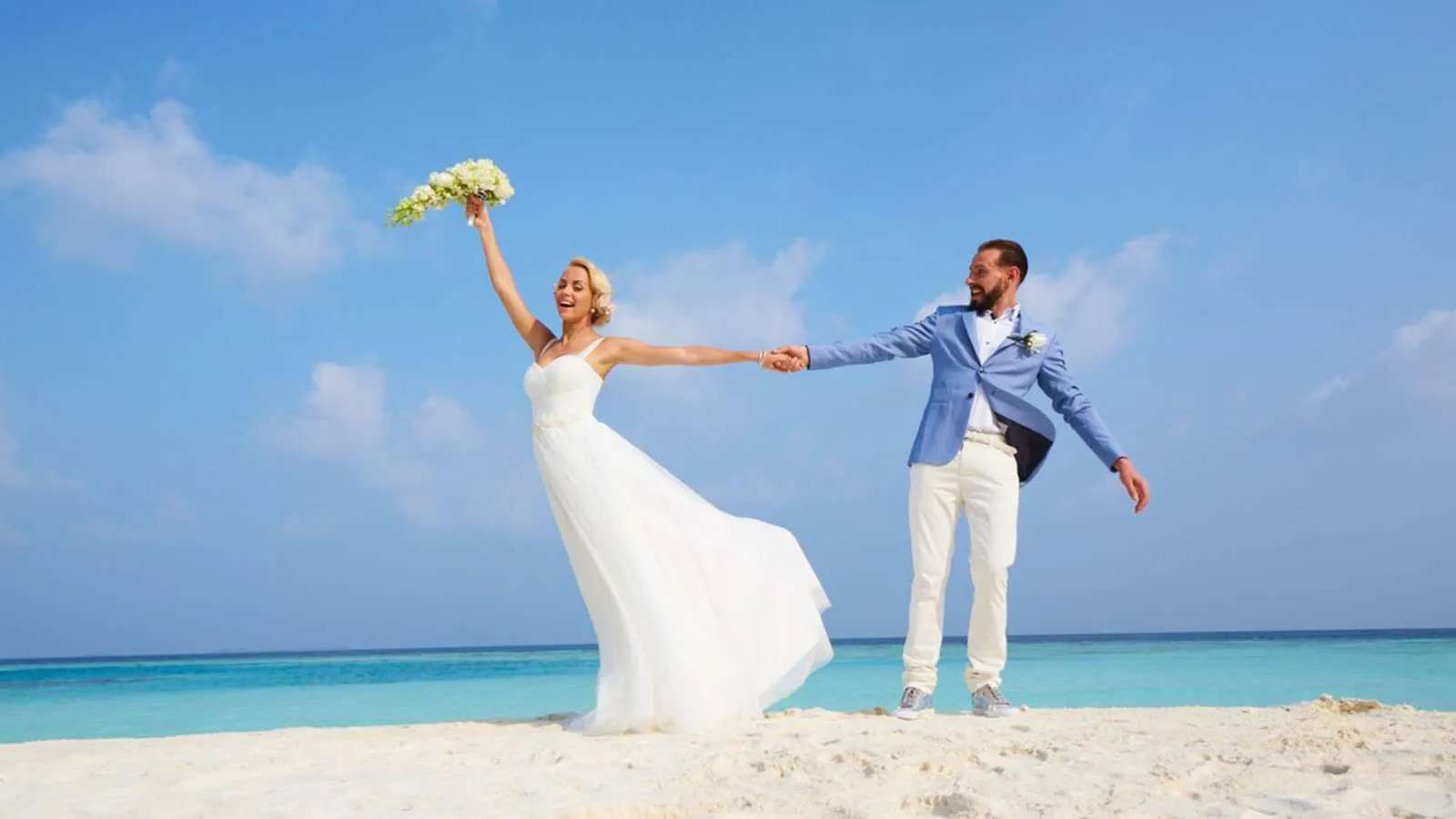 A couple on the beach at jawakara in the maldives for a vow renewal