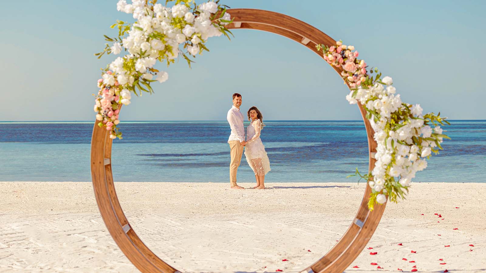 A couple on the beach at jawakara in the maldives for a vow renewal