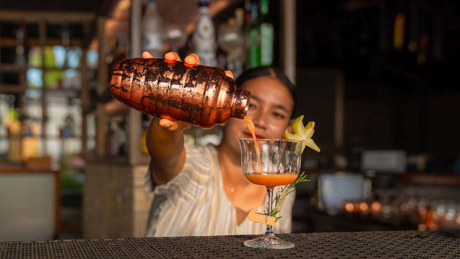 A girl pouring a drink from cocktail shaker Nala Maldives Island resort